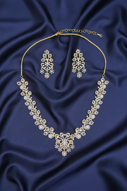 Trisha Necklace Set arranged on dark blue satin, showing gold-tone floral crystal necklace and matching chandelier earrings