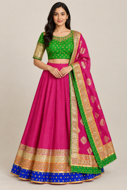 Front view of model wearing magenta lehenga and reference-inspired green blouse with gold sleeves