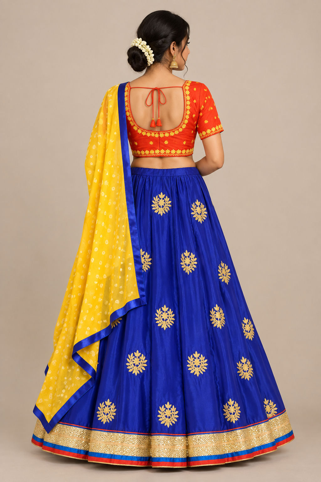 Rear view of model wearing blue lehenga and red-orange tie-back blouse