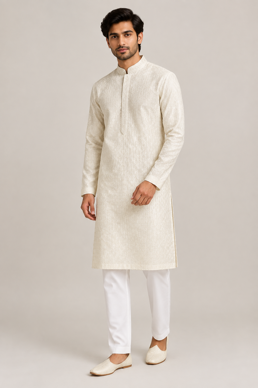 Male model wearing the ivory textured kurta with a stand collar and front placket band, white trousers and juttis, front three-quarter view