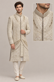Male model wearing ivory patterned layered sherwani, front three-quarter view