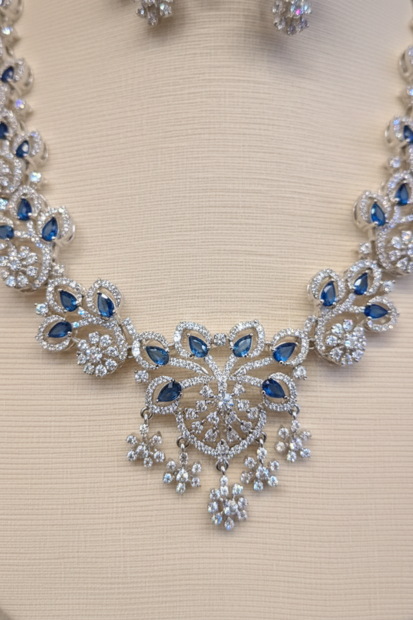 Close-up of the silver-tone necklace pendant with blue stones and clear crystal-style detailing