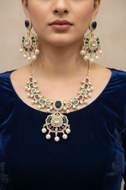Gold-tone floral necklace set with matching drop earrings worn with a deep navy festive outfit.