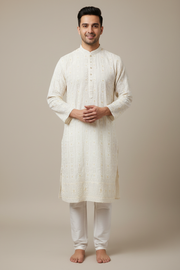 Male model wearing an ivory embroidered kurta and white pajama trousers, front view