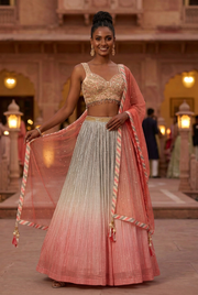 Front pose showing the floor-length silver-grey to coral ombre lehenga, embellished sleeveless choli and coral dupatta.