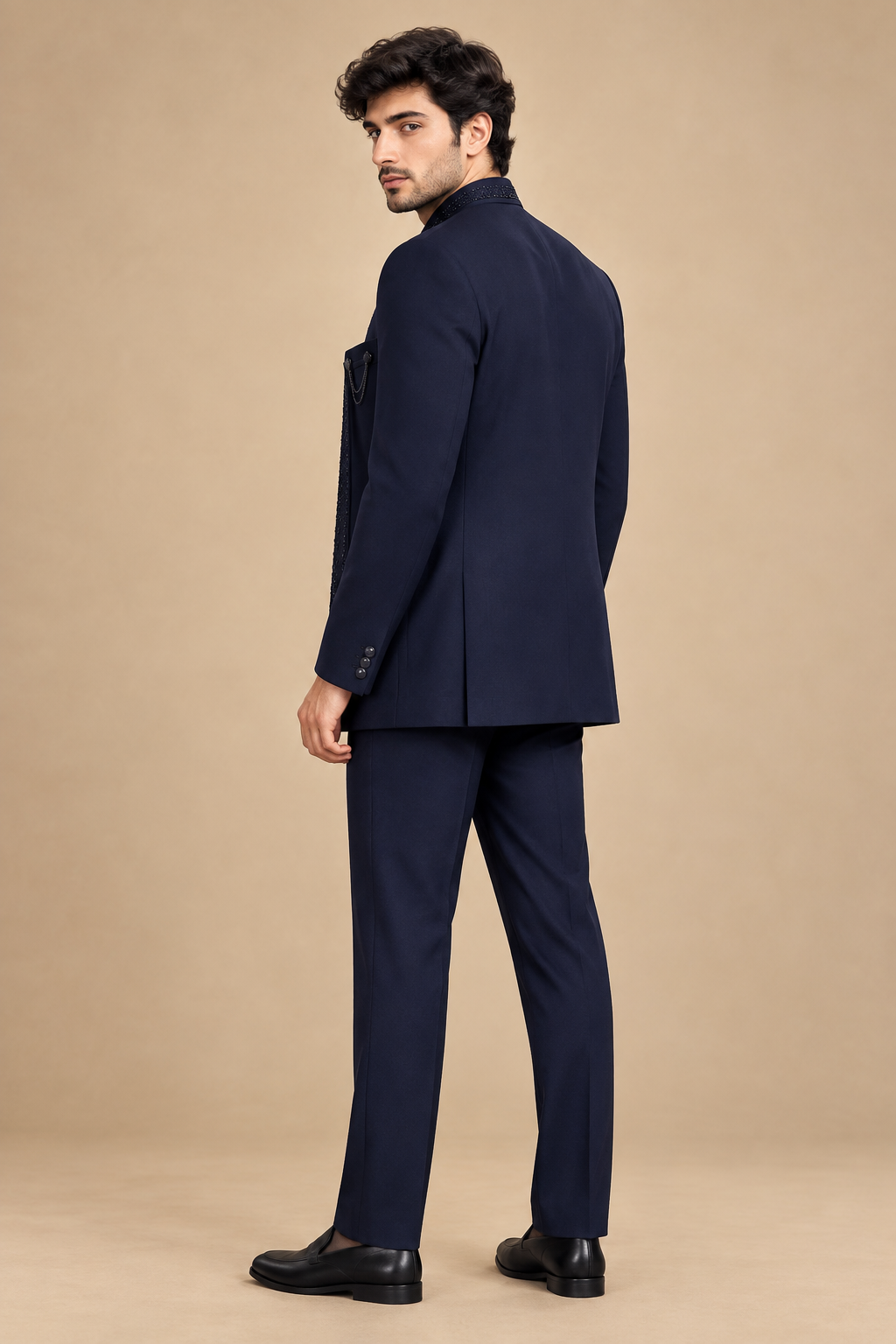 Rear three-quarter view of dark navy bandhgala jacket and matching trousers on male model