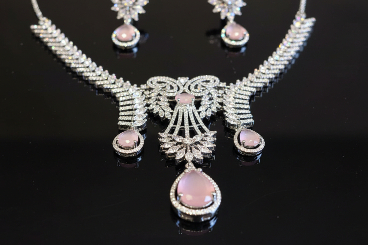 Close-up of the Shreya silver-tone necklace pendant with pale pink teardrop stones on a reflective dark surface