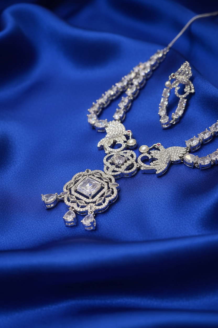 Angled close-up of the Shristi necklace pendant and earring on royal blue silk