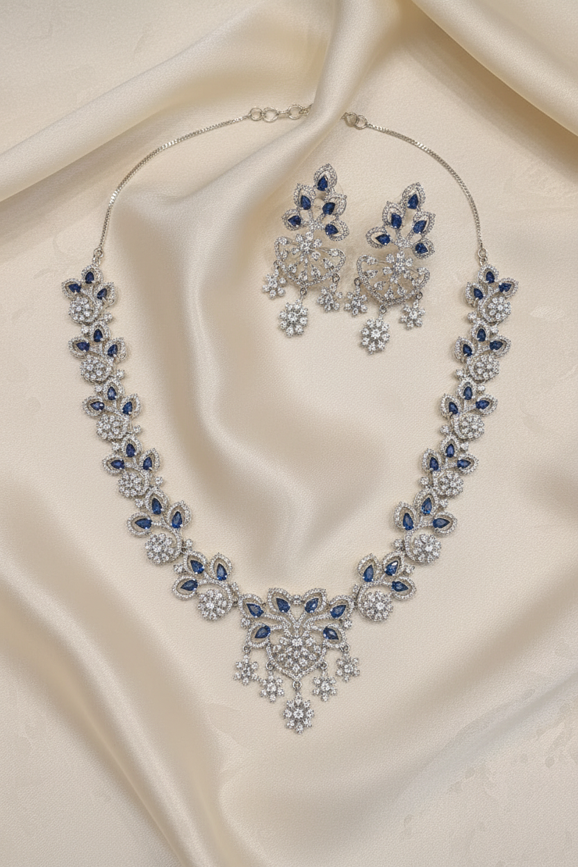 Silver-tone necklace and matching earrings arranged on ivory silk