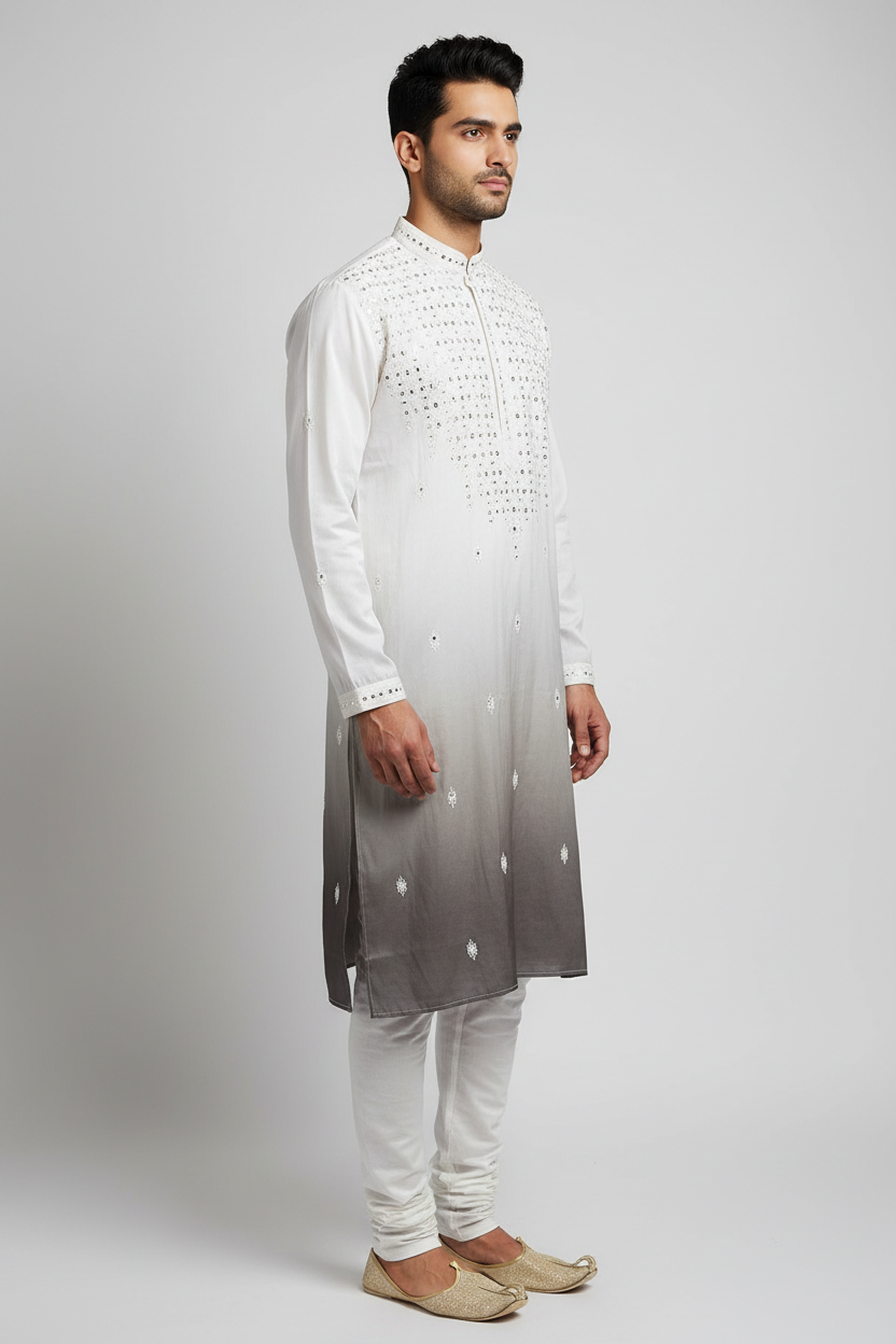 Male model wearing white ombre sequin kurta set with gold juttis - side profile