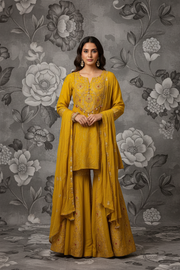 Model wearing mustard yellow embroidered sharara set, front pose